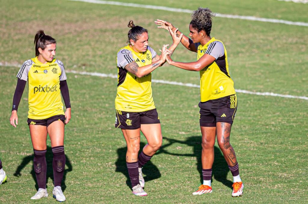 Glaucia e Duda se cumprimentam e Djeni observa durante jogo-treino do time feminino do Flamengo